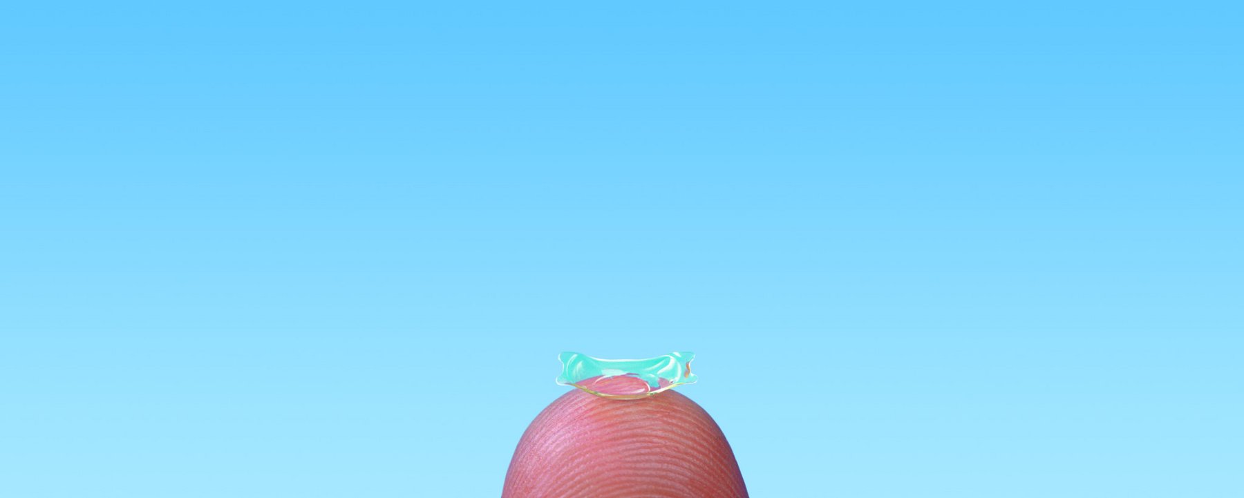 Implantierbare Kontaktlinse als Alternative für Brillenfreiheit, fotografiert auf einer Fingerkuppe