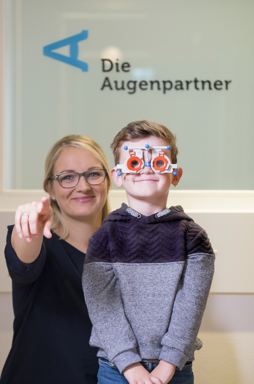 Bild zeigt kurzsichtiges Kind neben einer Orthoptistin der Augenpartner