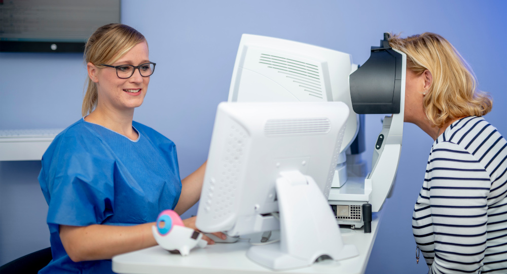 Bild zeigt eine Mitarbeiterin der Augenpartner bei der Untersuchung einer Patientin vor einer Grauer Star Operation