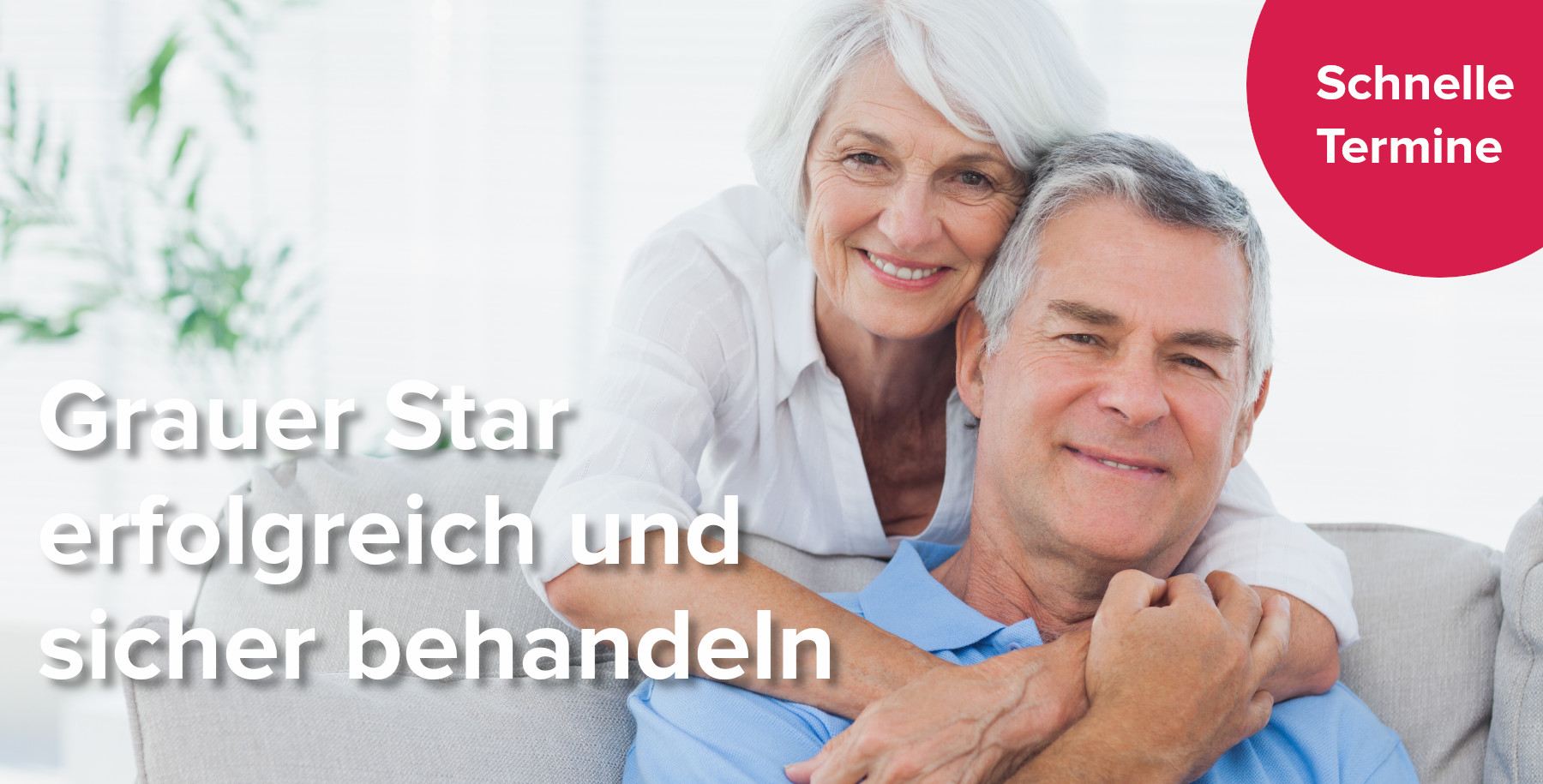 Ältere Frau umarmt ihren auf dem Sofa sitzenden Mann nach der Grauer Star Behandlung bei den Augenpartnern