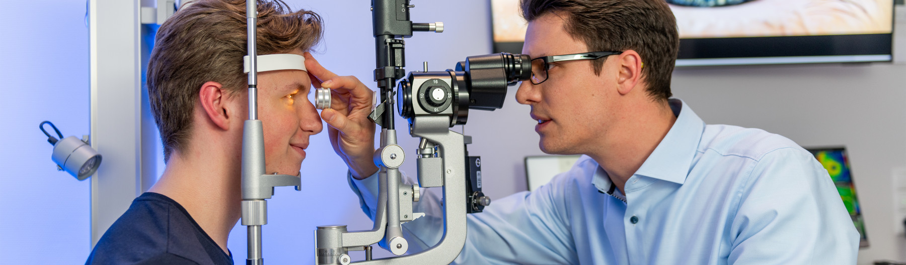 Augenarzt der Augenpartner Hoya untersucht einen jungen Patienten